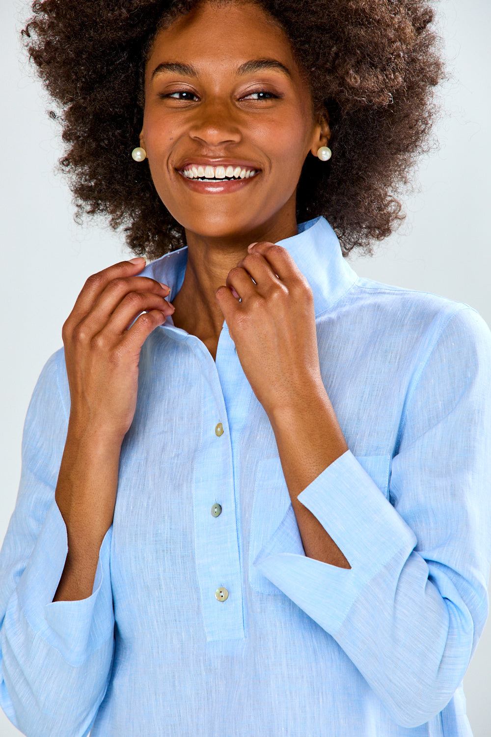Woman wearing a light blue shirt with a plain background