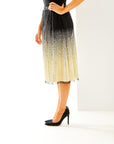 Woman in black and gold midi skirt