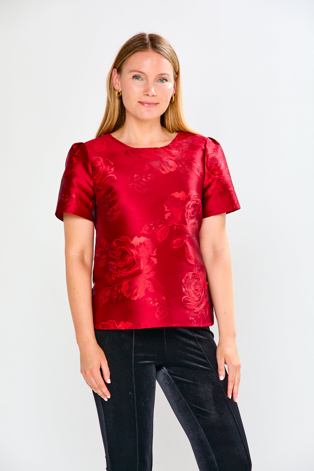 Woman wearing a red floral blouse against a white background