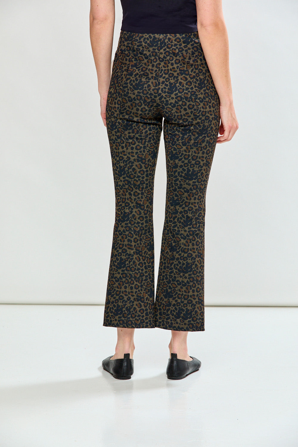 Woman wearing leopard print pants on a plain background