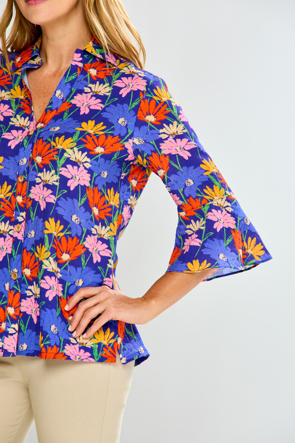 Woman wearing a colorful floral blouse with a plain background