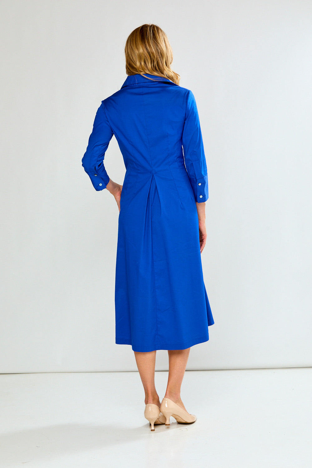 Woman wearing a blue dress against a white background