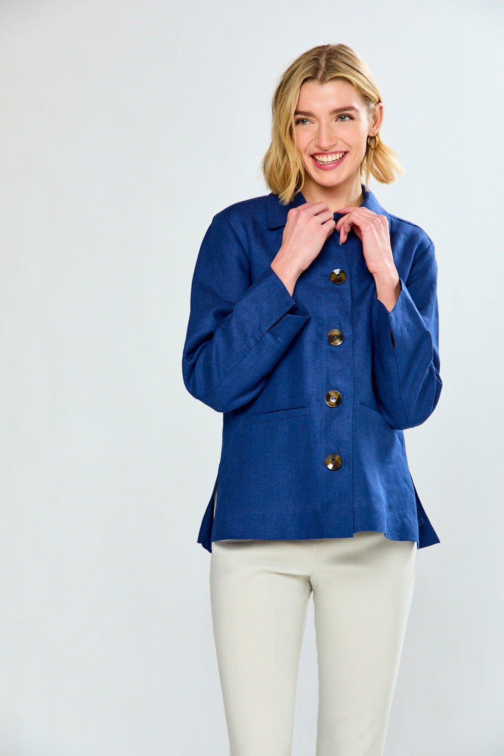 Woman wearing a blue jacket with buttons on a white background