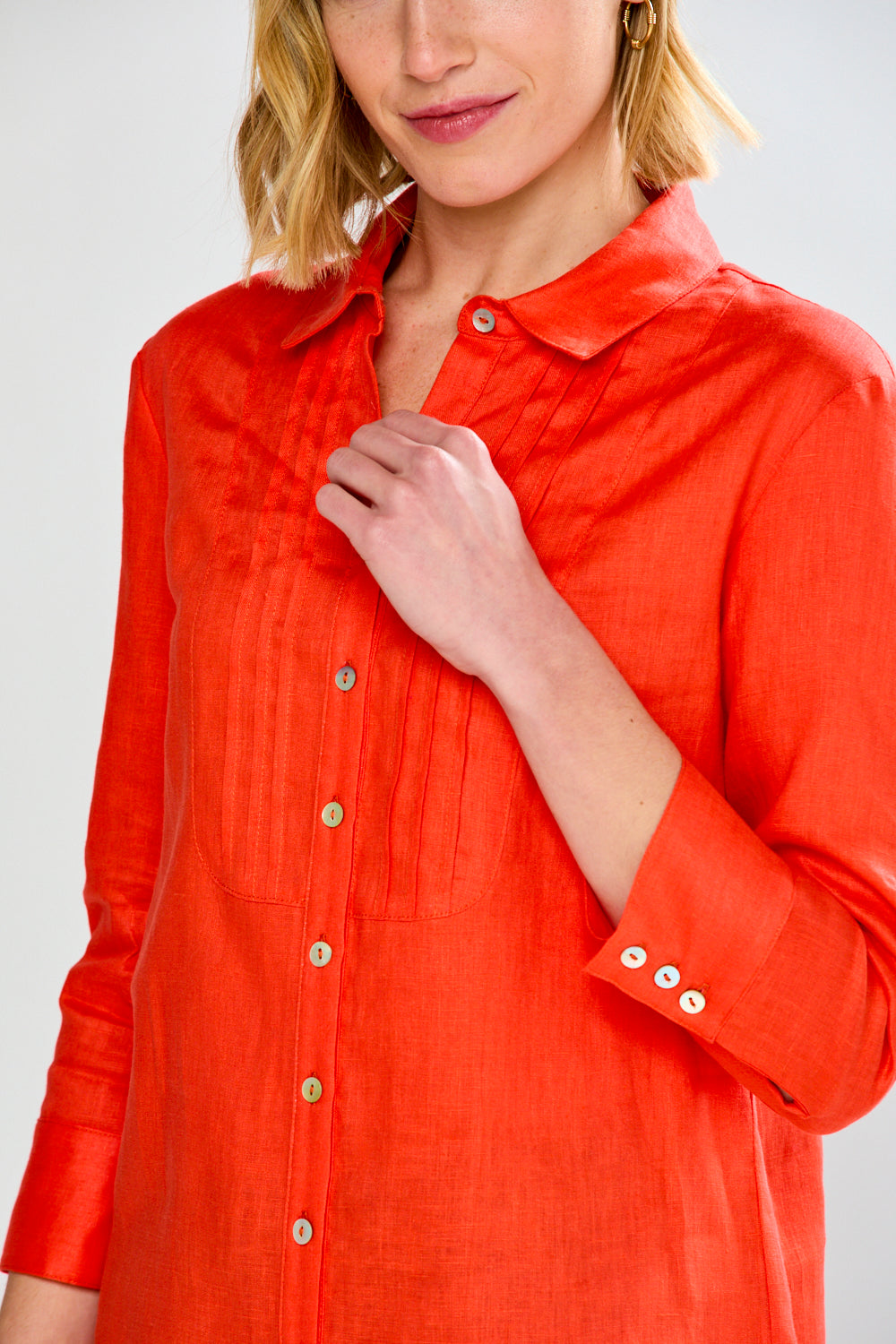 Person wearing a red button-up shirt against a white background