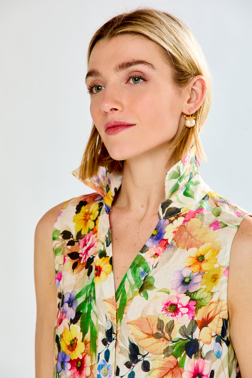 Woman wearing a colorful floral dress against a white background