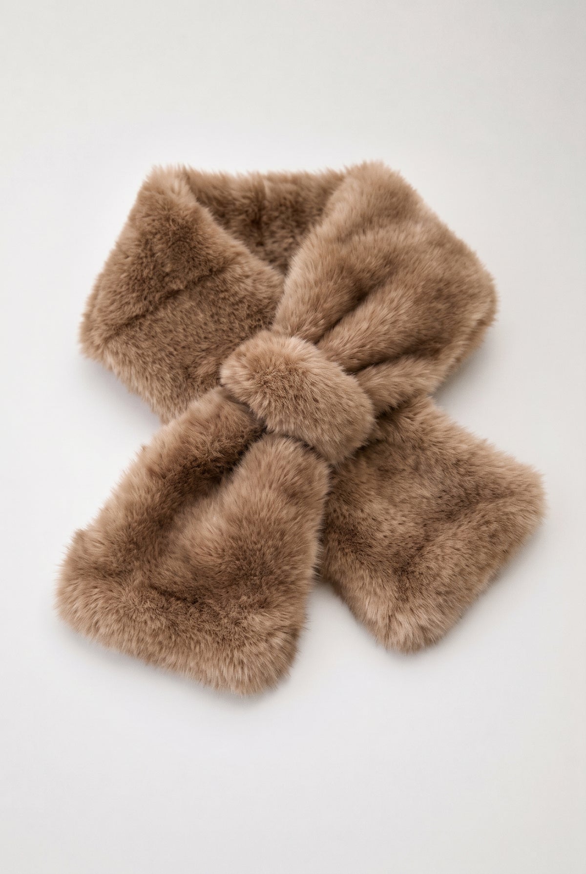 A light brown faux fur scarf tied in a bow shape, displayed on a clean white background.