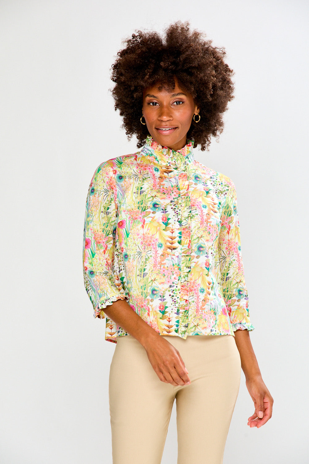 Woman wearing a floral blouse against a plain background