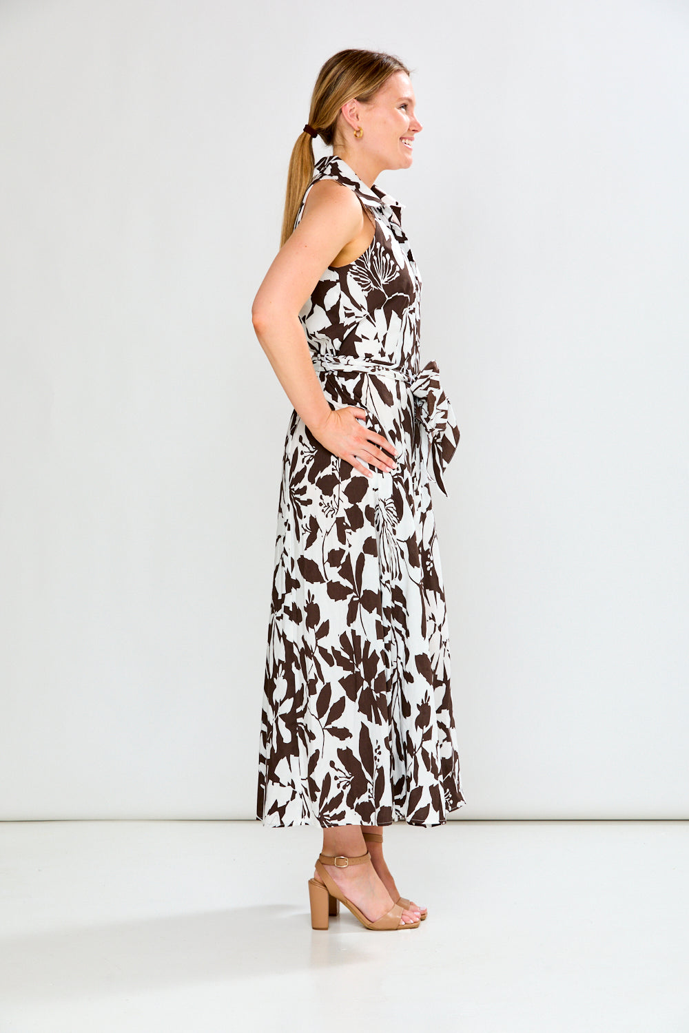 Woman wearing a sleeveless floral dress on a white background