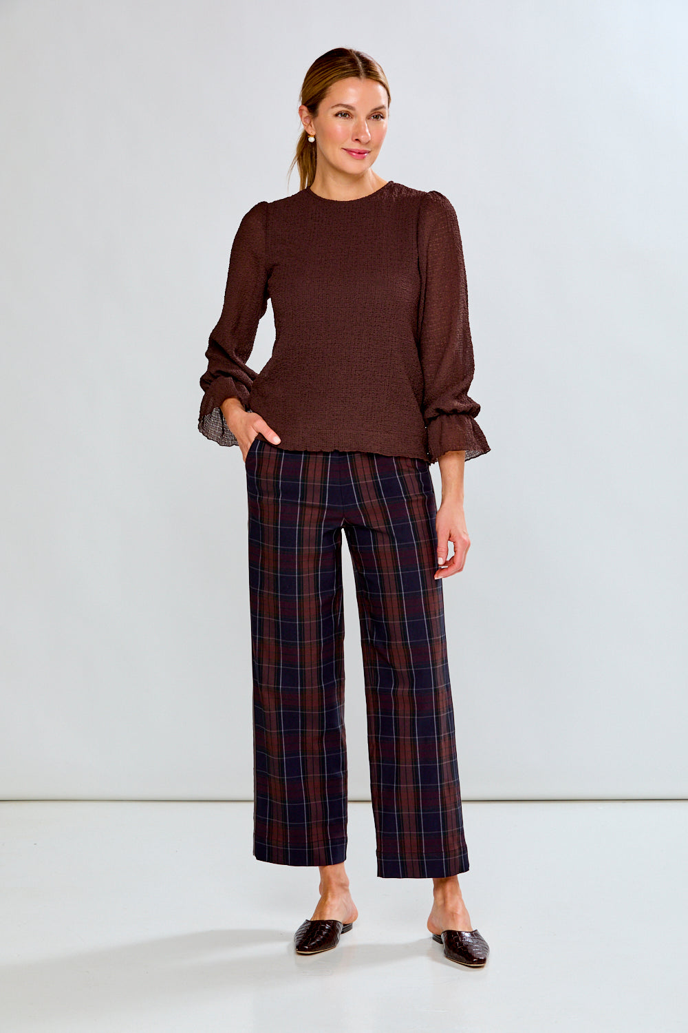 Person wearing plaid pants with a white background