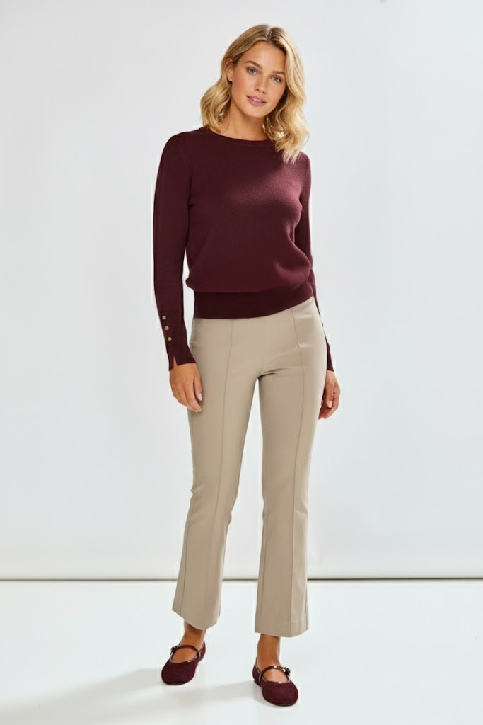 Woman wearing a burgundy sweater and beige pants on a white background