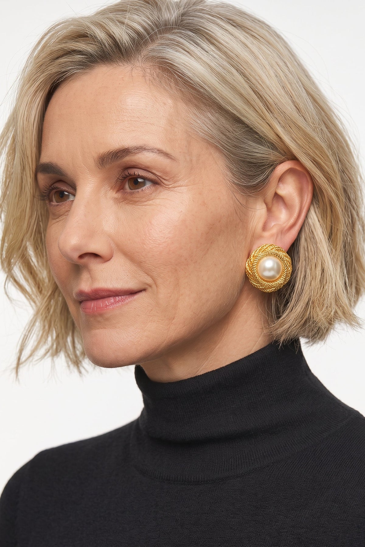 Woman wearing gold and pearl clip on earrings