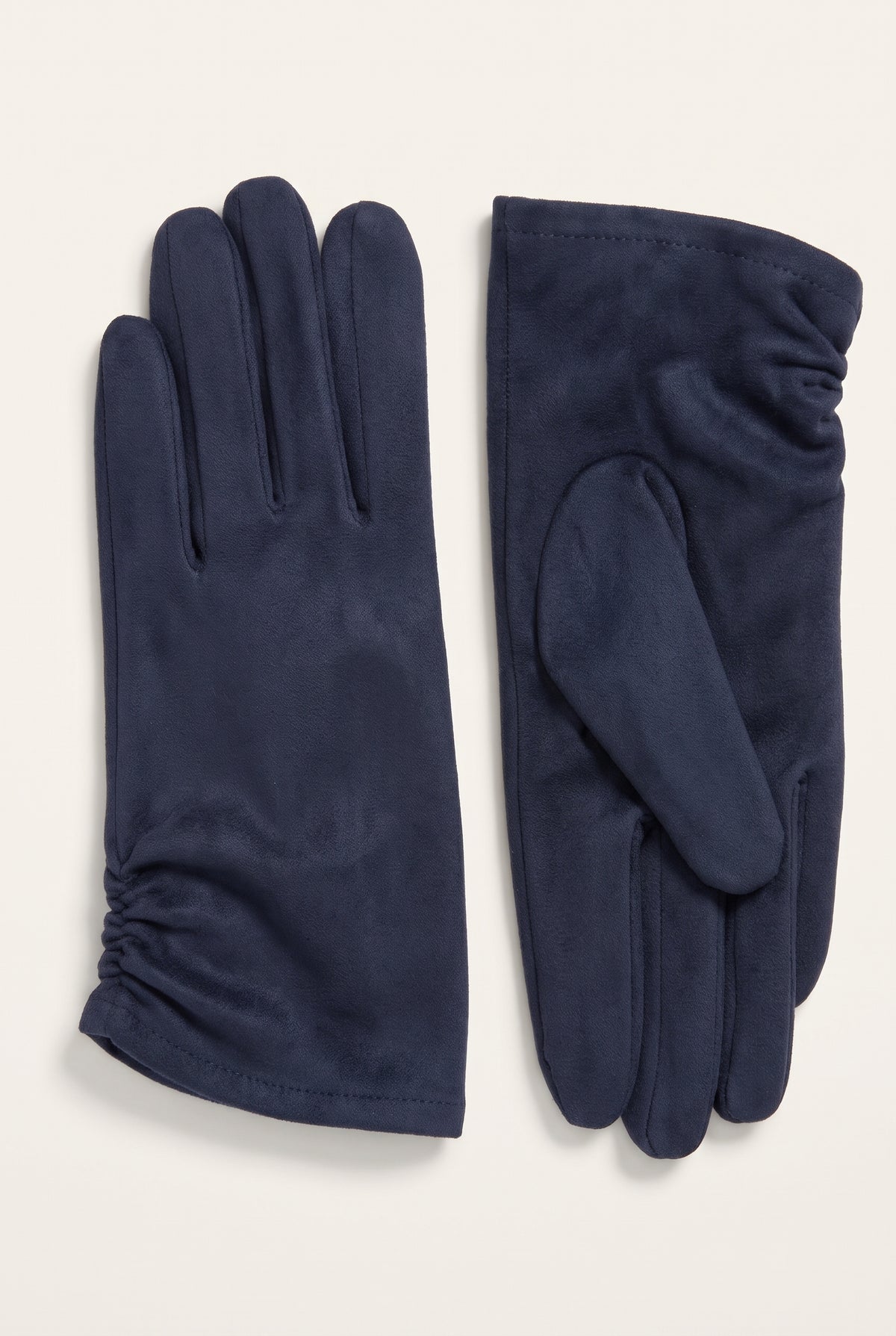 A pair of navy blue leather gloves, one showing the back of the hand with a gathered cuff and the other showing the palm side, laid flat on a light beige background.