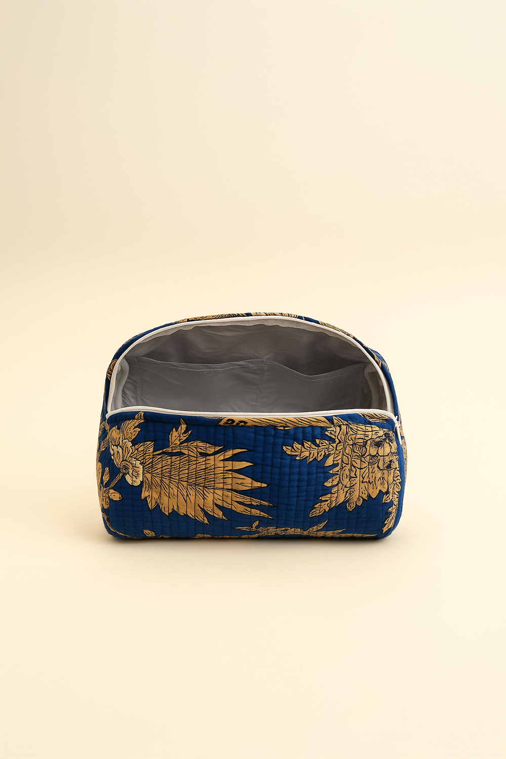 Blue pouch with gold pineapple pattern on a beige background
