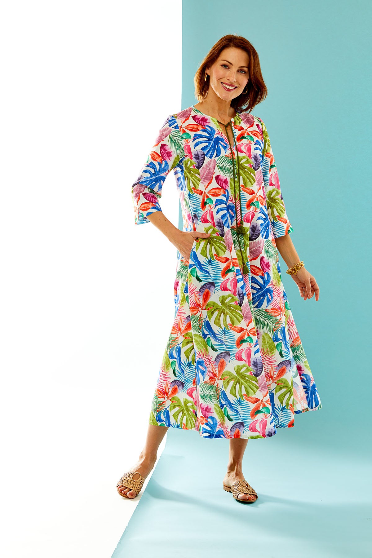 woman in multi-color palm leaf print caftan dress