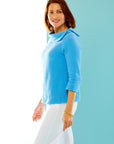 woman in ocean blue pullover with asymmetrical collar