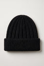 A black ribbed knit beanie hat with a folded cuff, photographed flat against a light gray background.