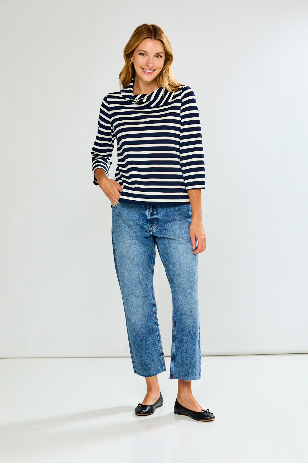 Woman wearing a striped shirt and jeans on a white background