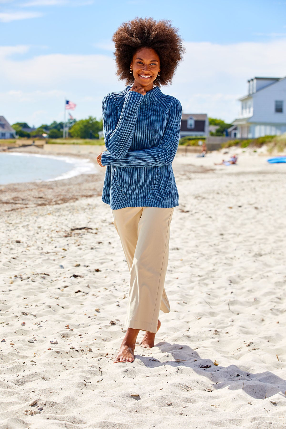 Woman on the beach wearing sand pants and a blue sweater