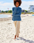 Woman on the beach wearing sand pants and a blue sweater